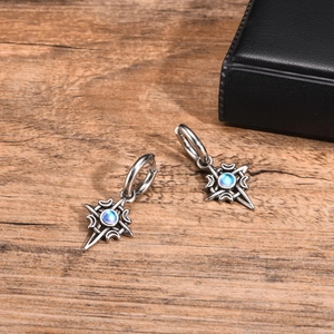 Macro shot of Celtic stainless steel hoop earrings with star moon and moonstone on wood