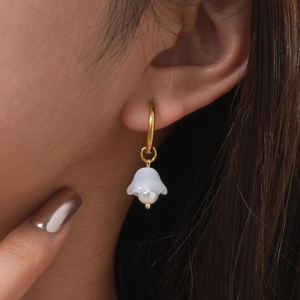 Detail of French vintage lily of the valley earrings with natural pearls on a model