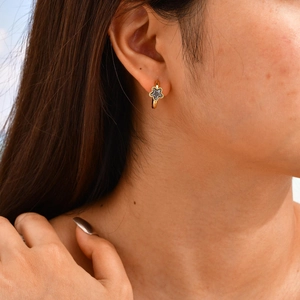 Vue macro de boucles d'oreilles créoles dorées avec pendentifs étoiles noires