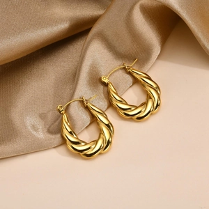 Detailed macro view of the twisted gold texture on these elegant U-shaped hoop earrings