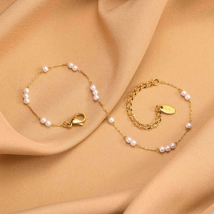 Detail of gold pearl anklet with K18 stamp on adjustable lobster clasp and satin fabric