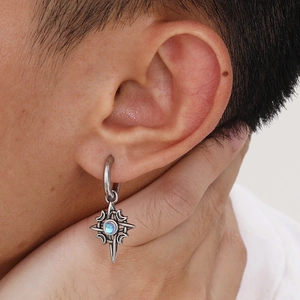 Close-up of Celtic moon star earrings with blue moonstone on a male model's ear