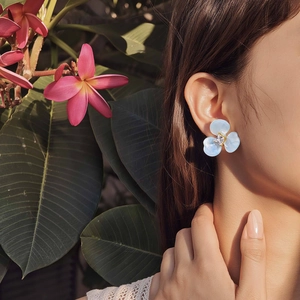 Vue détaillée d'une boucle d'oreille fleur bleue à trois pétales avec zircon carré