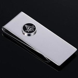 Polished stainless steel money clip with silver Freemasonry emblem on black background