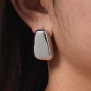 Close-up of geometric polished stainless steel earring worn for a minimalist daily look