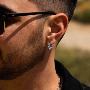 Close-up of a stainless steel spike hoop earring worn by a model in punk style