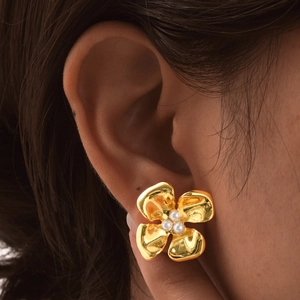 Elegant gold flower stud earrings with pearl centers on model in a French retro style