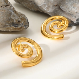Detailed view of 18K gold geometric spiral earrings on a natural stone background