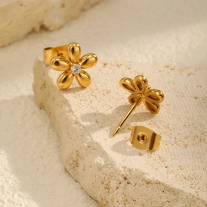 Macro detail of 18K gold-plated stainless steel flower earrings with tiny central zircon