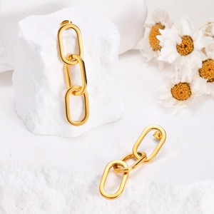 Détail des boucles d'oreilles pour femmes avec trois maillons dorés polis ovales