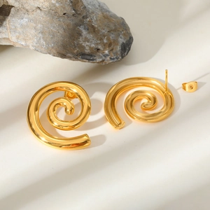 Detailed view of 18K gold spiral earrings with elegant light and shadow on stone background