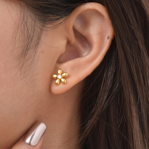 Macro detail of 18K gold stainless steel flower stud earring with zircon on ear