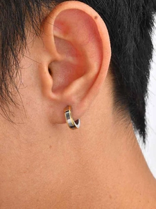 Gros plan de boucles d'oreilles créoles bicolores en acier inoxydable sur oreille
