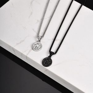 Detailed macro view of black and silver cross oval pendants on beaded chains