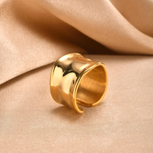 Close-up of a wide 18K gold stainless steel ring with irregular hammered wavy texture