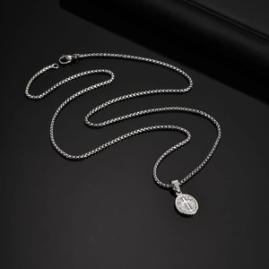 Detailed close-up of a silver vintage oval pendant with cross engraving and square link chain