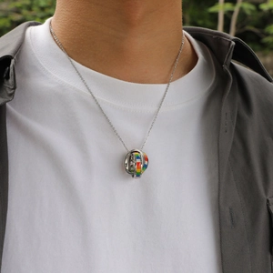 Détail du pendentif sphère astronomique argenté avec émail coloré sur chaîne fine