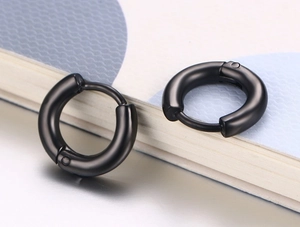 Vue macro de boucles d'oreilles huggie en acier noir mat avec fermoir charnière