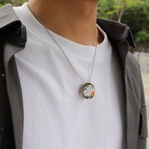 Détail du collier à deux anneaux entrelacés avec rayures arc-en-ciel sur un mannequin