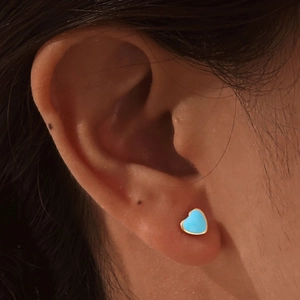 Detail of heart-shaped earring with teal enamel inlay and gold metallic border