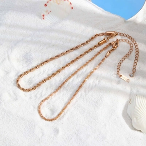 Ensemble de chevillières en acier inoxydable doré avec chaîne torsadée sur sable