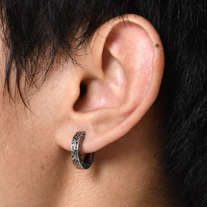 Men's retro stainless steel hoop earring with vintage engraved patterns on a male model