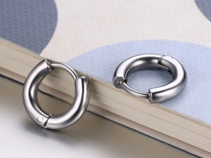 Vue macro de boucles d'oreilles créoles argentées polies avec fermoir charnière