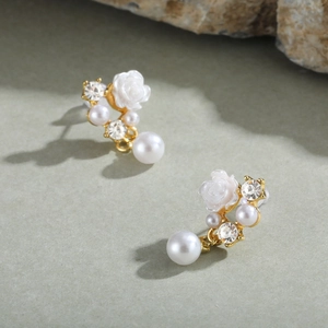 Detailed close-up of camellia flower earrings with faux pearls and gold alloy base