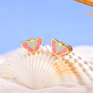 Detail van vlinder oorbellen met roze en blauw emaille op een witte schelp