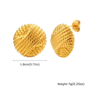 Macro detail of round gold-plated earrings featuring spiral woven textured patterns