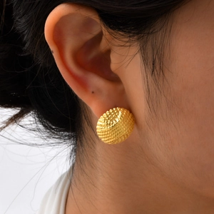 Textured round gold stainless steel dome earrings shown on a model for a realistic look