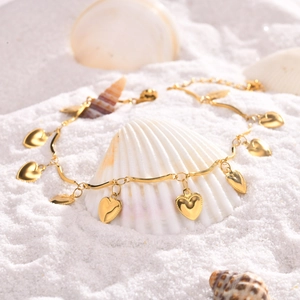 Détail de la chevillère en acier inoxydable 18K or avec cœurs sur coquillage et sable