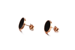 Détail de boucles d'oreilles en titane or rose avec centre acrylique noir et fermoir papillon