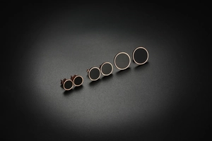Comparaison détaillée de trois tailles de boucles d'oreilles en acier rose et noir