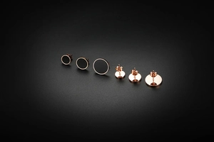 Trois paires de boucles d'oreilles en titane or rose avec disques noirs de tailles variées