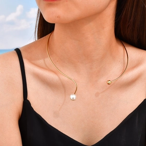 Détail du collier ras du cou doré avec perle asymétrique et perle sur le cou du mannequin