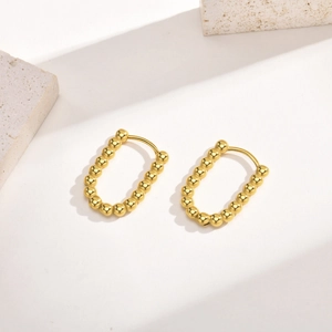 Detail of 18K gold plated stainless steel U-shaped hoop earrings with beaded texture