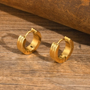 Detail of gold-plated stainless steel hoop earrings with vertical triple groove texture