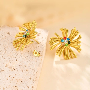 Détail de boucles d'oreilles vintage dorées avec strass multicolores sur pierre