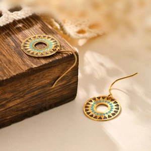 Detail of bohemian gold round earrings with blue and brown geometric enamel patterns