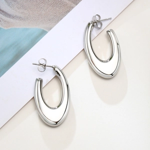 Close-up of polished silver teardrop earrings with a minimalist hollow design