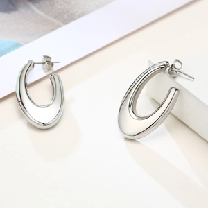 Macro view of polished silver geometric U-shaped chunky stud earrings with metal gloss