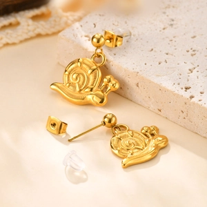 Macro detail of 18K gold plated snail earrings showing spiral texture and ear backings