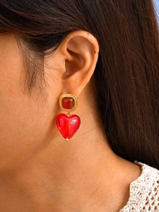 Gros plan sur des boucles d'oreilles cœur vintage en or avec breloques en verre rouge