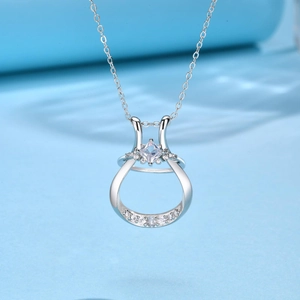 Dettaglio del pendente rotondo con diamante centrale quadrato e pavé su sfondo blu