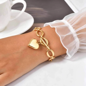 Bracelet élégant en acier doré avec pendentif cœur et fermoir OT porté au poignet
