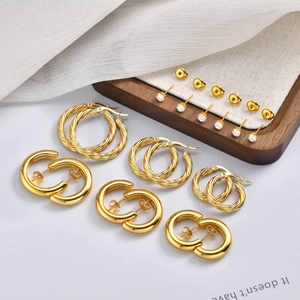 Three-piece gold earring set featuring twisted hoops, plain bands and zircon studs