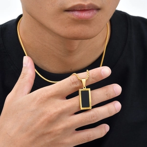Detailed close-up of a vintage black rectangular pendant on a gold stainless steel chain