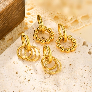 Chic gold stainless steel hoop earrings with bead details on a textured stone surface