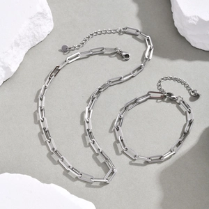 Silver stainless steel paperclip link chain necklace and bracelet set on stone